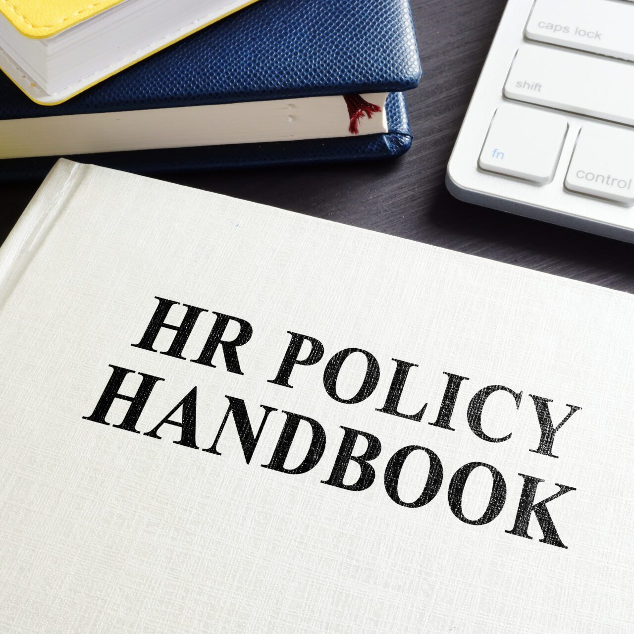 HR Policy Handbook on an office desk.